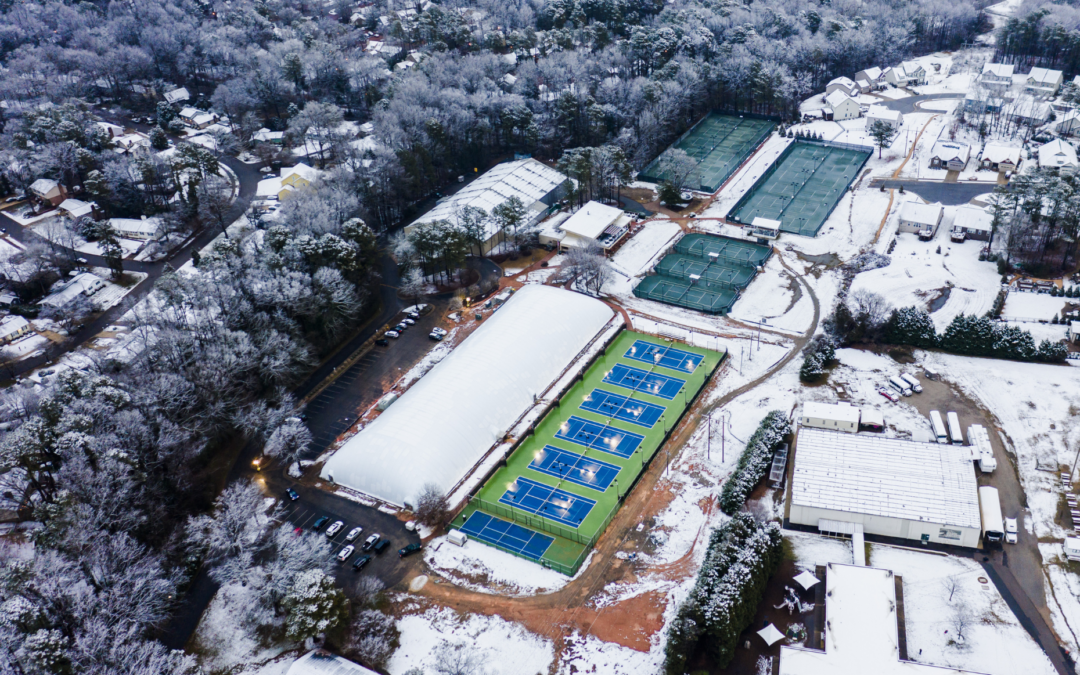 The photo shows a Farley tennis dome surrounded by snow.