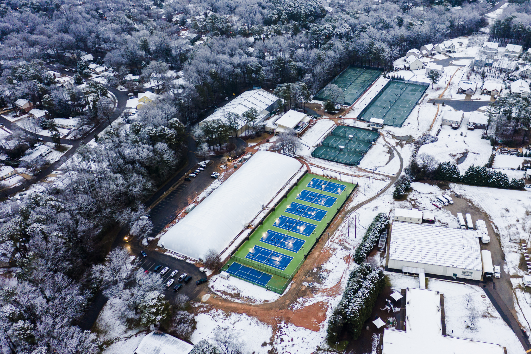 The photo shows a Farley tennis dome surrounded by snow.